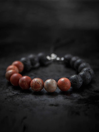 UAE OUTDOORS Muladhara chakra symbol on a textured background, representing the root chakra with vibrant red accents.
